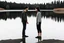 Placeholder: An image of two people exchanging criticism in a constructive and respectful manner, standing on the ground with a lake behind them