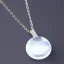 Placeholder: Clear polyester necklace with a simple, elegant design featuring a single, shimmering crystal pendant