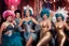Placeholder: high res photo of a vintage burlesque show: feathers, scarfs, there are glitter and sparkles everywhere, a groupe of show women