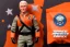 Placeholder: Mike pence G.i. Joe toy Space force uniform With accesories inside a blister packaging hanging on a Wallrack in toystore, fluorescent orange, toy guns, wide angle shot whole body, black moonboots, fullsize