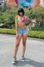 Placeholder: a hot, extremely well-endowed female named Brenda Freemont, with short, crew-cut, Black Hair, wearing a tight, ill-fitting, colorful, multicolored tie-dye swim suit top, and extremely short jean shorts, and converse sneakers, posing at Disneyland