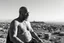 Placeholder: man looking like "Walter White" in breaking bad tv show, bald and goatee, with bare chest riding on a camel in Casablanca town, panorama, black and white photo, staring at a small town in horizon