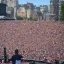 Placeholder: one man on stage in front of massive crowd