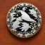 Placeholder: coaster of kingfisher ivory brooch with black pearl inlay, opalescent marble carving, decorative design, classical ornament, highly ornate, highly intricate, highly detailed etching, marble carving, warm lighting, linen backdrop