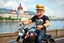 Placeholder: 3D video game characters, a short blonde haired man wearing eyeglasses, t-shirts and jeans riding a motorcycle , Hungary, Budapest, Parliament, hearts, riverside, castle hill, happiness