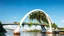 Placeholder: A stunning pedestrian bridge with large parabolic arches supporting the structure, gracefully rising above a river. The bridge incorporates floating gardens and hanging vines, which cascade from the arches, blending nature and mathematical precision. The elegant parabolic arcs create a sense of balance and harmony between the bridge and its natural surroundings. Award-winning photograph.