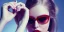 Placeholder: Scarlett Leithold intense red lips with green glasses backlit at night