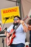 Placeholder: a very immature adult man playing music, cartman south park, sign in background that says "Warning!" "immature"