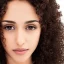 Placeholder: Amal, male, dark brown eyes, darkest brown mid length curly hair, real human face, ultra high resolution