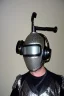 Placeholder: Metallic Cyber-punk style man with a web-camera-mask and old AKG-style headphones with golden rings. Large fencing mask covers man's cheeks. Good body shape. Reflective plastic. Body and head full of integrated old-fashioned cameras. Ancient silver telephone attached. perfect body. Euclidean 3D-tiling, Escher tiling, background. Cables from shoulder, connect. Daft Punk, Matrix movie black leather jacket with a Hood. Yellow latex areas in black leather surfaces body. 1990's. Porsche-Trypophobia