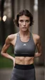 Placeholder: photography of a beautiful anorexic woman, grey satin triathlon top, sports illustrated, brunette short wavy bob haircut, pronounced sternum, flat chest, anthracite short leggins