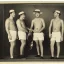 Placeholder: a group of four male friends with very small shorts on and large hats and holding trombones