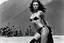 Placeholder: [photo by helmut newton in agent provocateur on the arena] Her complexion, after years spent training under the sun, bore the mark of a warrior who had weathered countless battles. Though her face spoke of hardship, there was also an air of grace and serenity that emanated from her every pore. Selene's physique was a testament to her dedication and discipline. Her muscular frame hinted at her physical prowess, yet her movements were fluid, as if she danced with the wind itself.