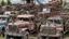 Placeholder: A reddish gray trashed junkyard with broken down construction vehicles designed in Hawaiian tiki statues painted by Claude Monet
