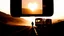Placeholder: A modern cinematic video about heartbreak and separation. A lone person stands on an empty road at sunset while a train or caravan disappears into the distance. The scene is emotionally powerful, realistic, and visually elegant. Show modern symbolic imagery: reflections in glass, a phone screen lighting up with an unanswered message, a floating dust cloud, a broken mirror, and a silhouette walking away through soft fog. Use dramatic camera movement, shallow depth of field, emotional close-ups,