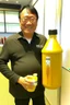 Placeholder: Robert Kiyosaki standing next to giant golden milk bottle that say milk on STYLE OF HIROKU OGAI