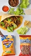 Placeholder: "Taco in a Bag" which consists of an open Doritos chip bag containing Doritos chips and cooked ground beef and lettuce and shredded cheese and tomato pepper and onions and more naco chips, food blogger photography