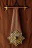 Placeholder: darker textured hanging fabric background, with decorative brass corners at top, and a heavy brass decorative element attach across the bottom