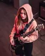 Placeholder: attractive woman wearing a hoodie and playing an electric guitar at high angle