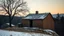 Placeholder: a lonely old adobe hut with worn adobe brown-gray wall and a small window, a crumbling roof, an old chimney stands on a hill, next to it is a small woodshed by the wall, and an old withered tree leans over the hut, the hut stands on the edge of a European forest, winter, snowy landscape, low light, dawn, high detailed, sharp focus, high realistic, perfect photo