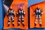 Placeholder: Mike pence G.i. Joe toy doll space force uniform inside a blister packaging hanging on A rack in toystore, fluorescent orange, wide angle shot whole body, black moonboots, fullsize