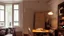 Placeholder: intimate and reflective atmosphere, open space + kitchenette, bookcase, lamps, signature paintings, a woman in the dim light looking out the window, scattered sheets on the table,