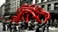 Placeholder: In this photograph taken in a street in New York, single building deattached and lifted from the foundation and moving. It got multiple long, flexible tentacles or appendages extend from its body, each adorned with repeated patterns of red and black rings. These tentacles end in claw-like structures. The tentacles are trying to catch office workers. People screaming and runaway in panic.