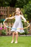 Placeholder: a pretty 7 years old girl with blue eyes and nice dress and shoes play hula hoop in children play garden