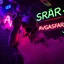 Placeholder: A exhaust pipe performing at dance club, his name is "exhaust pipe" and looks crazy, looks very aggressive look, Neon lights and smog, "AVGASRÖR" SIGN ON WALL