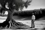 Placeholder: Al estilo visual de la primera temporada de la serie True Detective, un hombre observa una tumba de arena junto a un gran árbol sobre la que reposa una cornamenta de ciervo, fotografía en blanco y negor. Disparo con cámara Leica