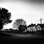 Placeholder: A landscape, odd black and white old photo, dystopic atmosphere, trees, some odd houses, George Grosz