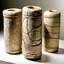 Placeholder: clay cylinders covered with strange etchings. small and fragile, with large cracks running down their sides