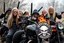 Placeholder: a very hard and tuff motorcycle young gang with long blond Sweden viking hair, not old, posing with their Harley Davidsson bikes, some of them holding guns and shotguns, a logo sign with Falköpings HD Club, "Fearless sinners" Skulls and bones, skeletons and fire, Sweden vikings DEMONS