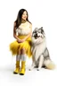 Placeholder: large white dog in a feather dress, next to a girl in a yellow sweater, a gray skirt, white stockings and black shoes, both facing the front in the photo. white background, 16K, real photography, portrait.