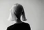 Placeholder: Mujer rubia de espaldas, retrato primer plano., iluminada desde desde el rostro hacia la cára, al estilo de la foto del fotógrafo Hugo Alonso. Imagen en blanco y negro vaporoso
