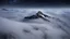 Placeholder: looking down from space at a misty mountain coming through the mist and surrounded by the mist at night starry sky