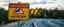 Placeholder: roadside sign warning about dangerous artwork in the road