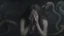 Placeholder: A woman with medium skin tone , appearing to be in her 20s , is shown with her hands covering her face, expressing a sense of distress or contemplation . Her hair is dark and flows around her. The background is dark and abstract , featuring faint images of a serpent and a stylized face , creating a mysterious atmosphere