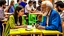 Placeholder: A 30-year-old teacher in the university cafeteria looks at an old man, 60 years old, sitting at another table next to hers, Egyptian complexion.