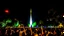 Placeholder: ciudad de buenos aires, es de noche, hay un montón de gente alrededor bailando y tomando, luces blancas y coloridas, se muestra el obelisco, fiesta, festejo, manos arriba