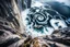 Placeholder: at the base of the rocky mountain peninsula, a great whirlpool waterfalls into deeper unknown depths