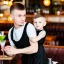 Placeholder: Russian guy boyish boylike short man's haircut boyish features in black girlish lacy cocktail dress as mother in restaurant