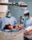 Placeholder: image of two doctors in a hospital surgical theatre holding a newborn baby