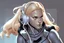 Placeholder: a blonde, white woman with a headset who is sitting down typing on a laptop, graphic novel, highly detailed in the comic style of travis charest,