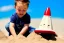 Placeholder: Toddler elon musk builfing a rocketship sand castle on the beach