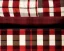 Placeholder: Red plaid slippers on black bearskin rug,log cabin walls, big stone fireplace