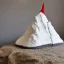 Placeholder: Model of the Matterhorn made of wool knitting, grey and white, mountains in the background