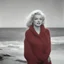 Placeholder: Marilyn monroe with long plaids, in a large red woollen sweater, on the beach, in the sun