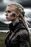 Placeholder: Una mujer rubia con el pelo con trenzas con apariencia vikinga vestida con cuero negro sus brazos con tatuajes en una isla con un día nublado