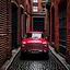 Placeholder: The Mini Cooper parked in an old alleyway and it 's red .